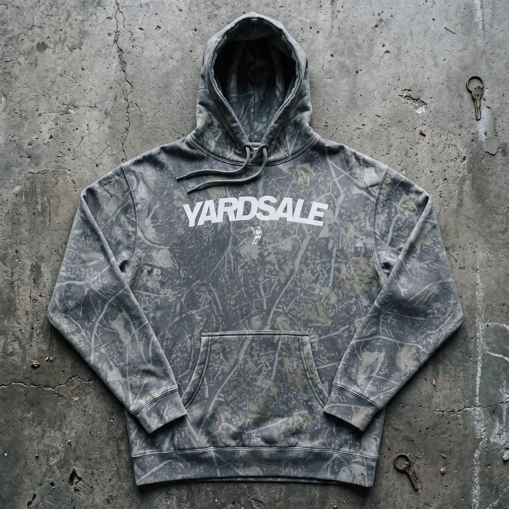 Gray tie-dye hoodie with 'Yardsale' text on a concrete surface