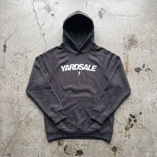 Gray hoodie with 'Yardsale' logo on a textured concrete surface