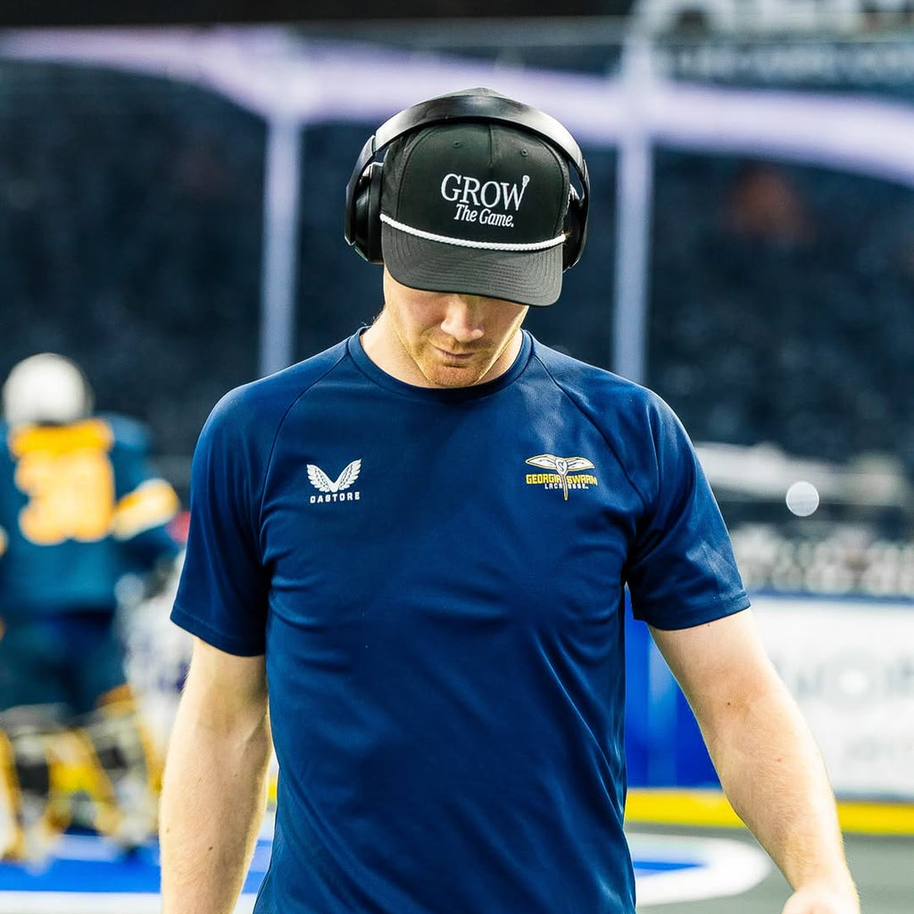 Person wearing a blue sports jersey with visible branding in an indoor sports facility.