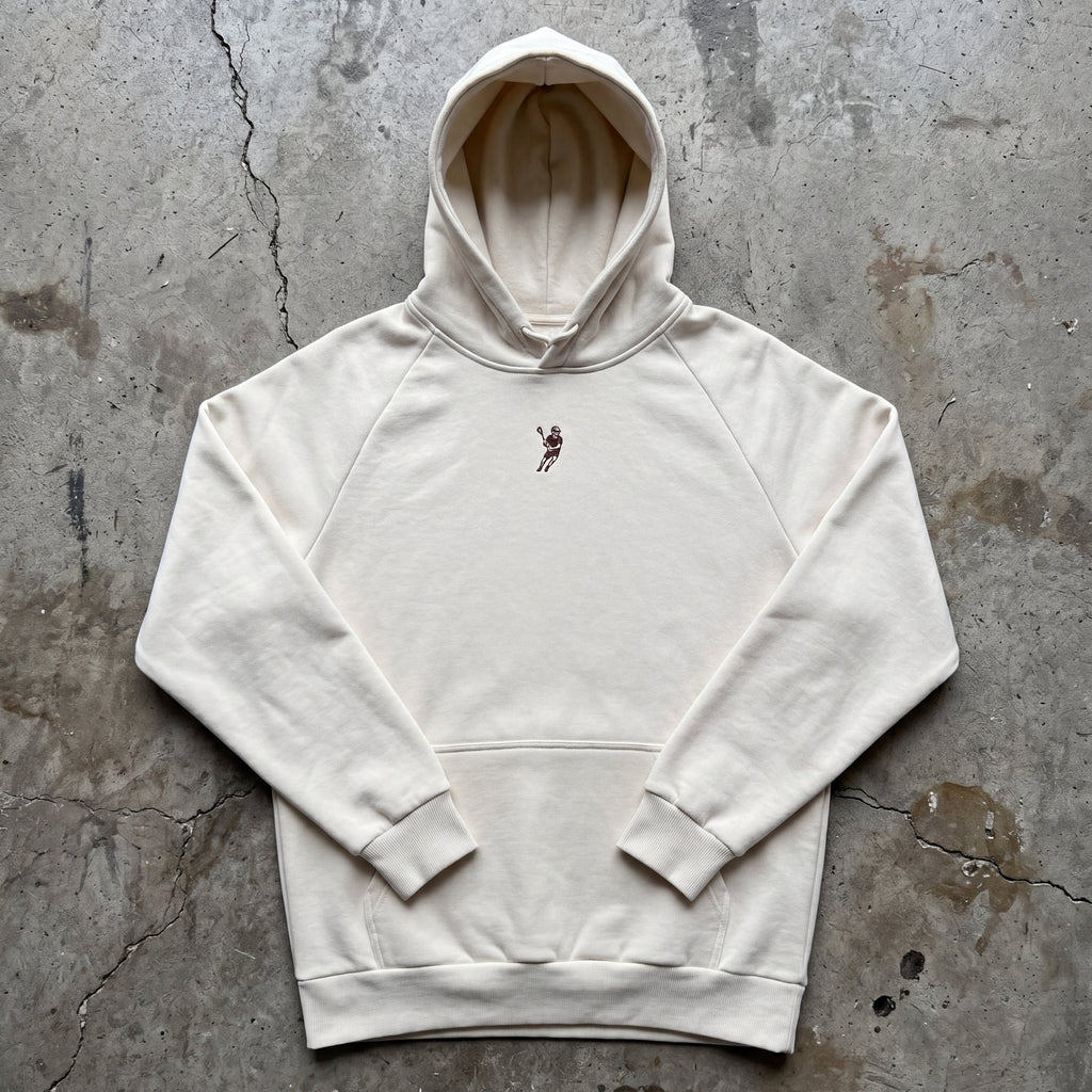 White hoodie with a small graphic on a textured gray surface