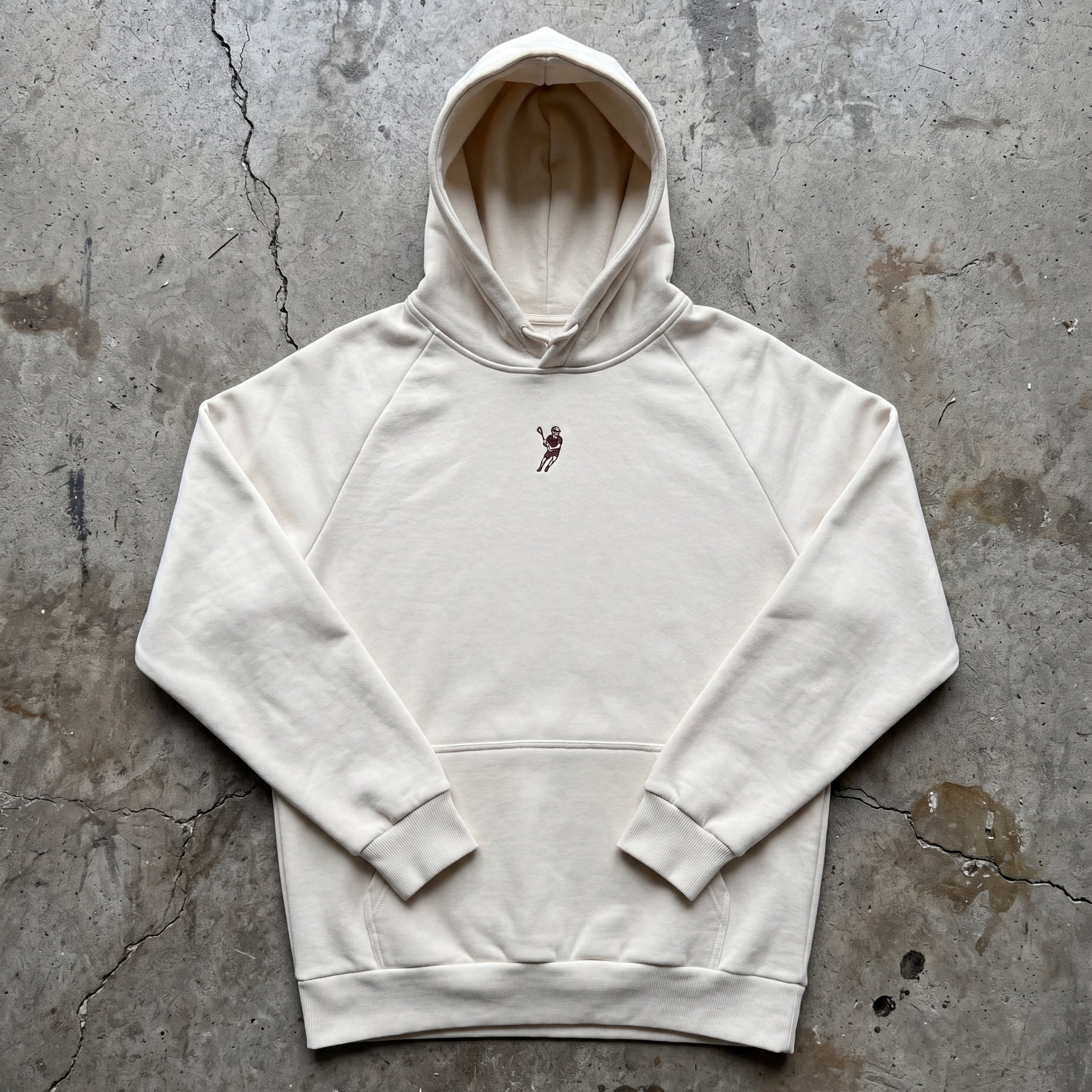 White hoodie with a small graphic on a textured gray surface