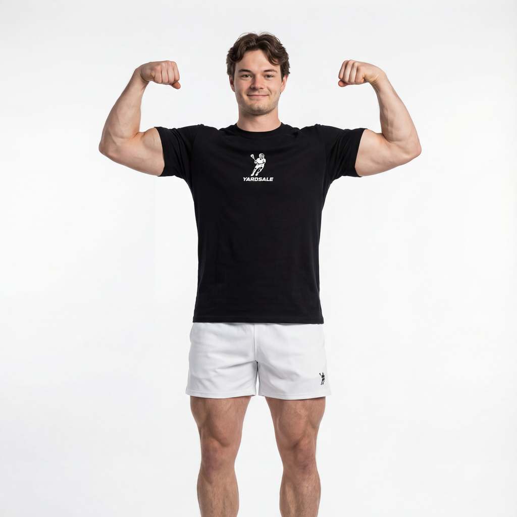 Man flexing muscles wearing a black t-shirt and white shorts on a white background