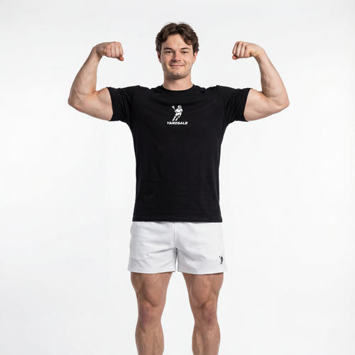 Man flexing muscles wearing a black t-shirt and white shorts on a white background