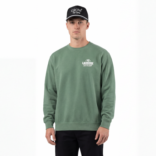 Man wearing a green sweatshirt with a logo, black pants, and a black cap on a white background