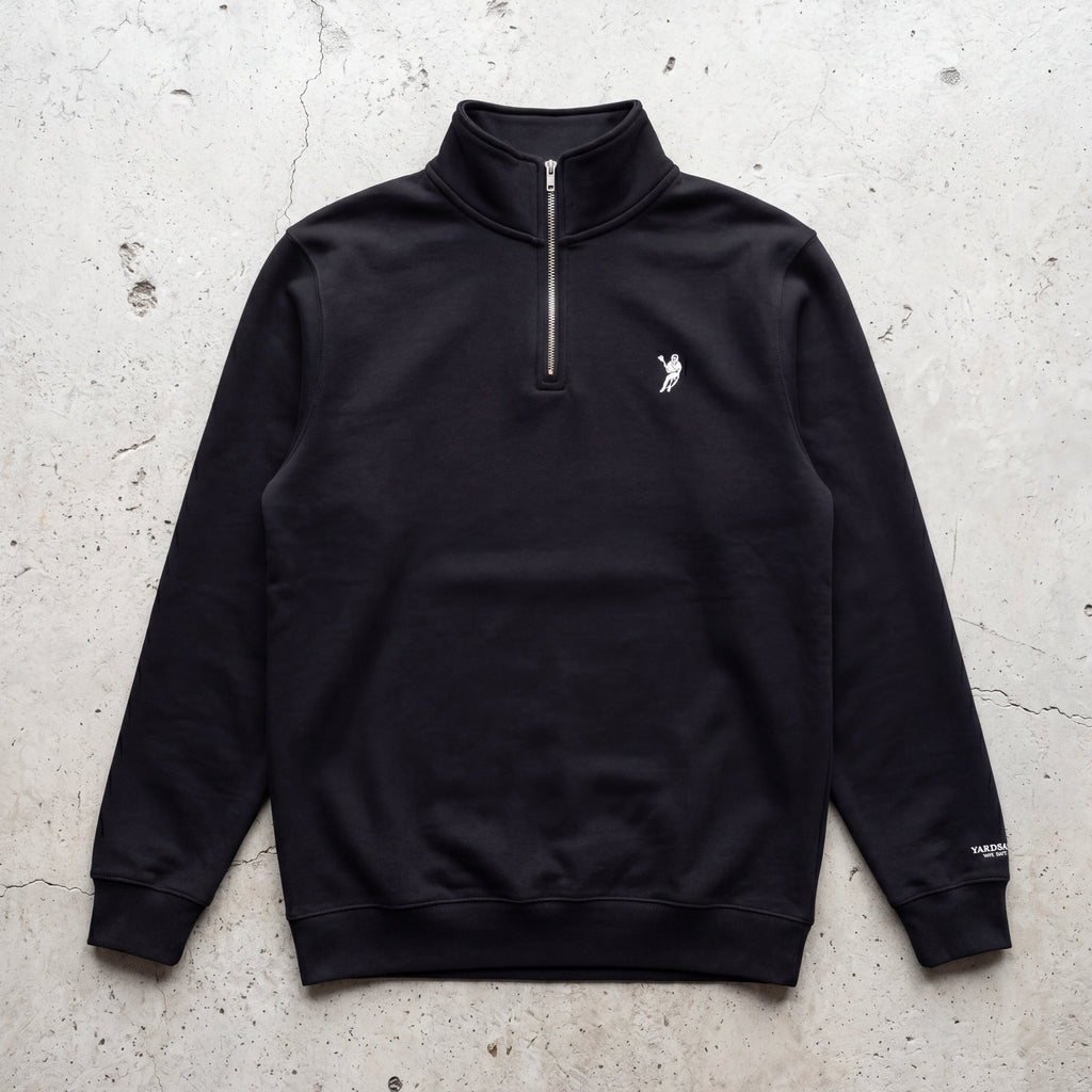 Black quarter-zip sweatshirt with a logo on a textured light gray background